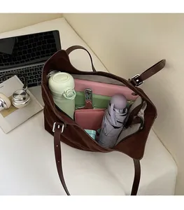 Vue de l'intérieur spacieux du cabas en daim marron avec accessoires du quotidien