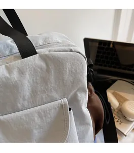 Close-up of the ripstop nylon fabric and stitching detail on the crossbody bag