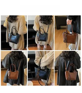 Detailed views of vintage matte bucket bag in black and brown with stylish tassel accents
