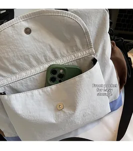 Detailed view of the magnetic front pocket on a casual crossbody bag showing storage space
