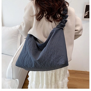 Detail of large navy blue checkered canvas tote bag featuring pleated shoulder straps