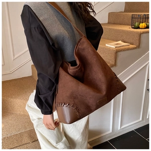 Detail of leopard print tote bag with brown leather corner patch and sturdy hand stitching