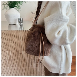 Detailaufnahme der braunen Plüsch-Beuteltasche mit Kordelzug und Lederriemen für Damen
