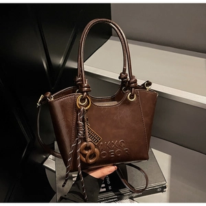 Detail of dark brown vintage faux leather texture with embossed letters and gold hardware