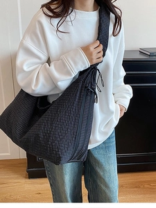 Black and grey plaid canvas crossbody bag with pleated texture and drawstring details
