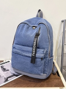 Blue denim college backpack with fashionbag strap and large front pocket on desk