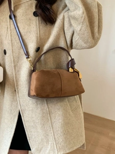 Elegante borsa a cuscino in camoscio marrone con fibbie dorate e tracolla su modella
