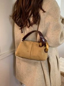 Borsa a bauletto in pelle scamosciata gialla con grande fibbia dorata su modella