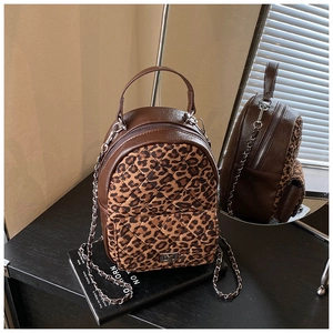 Détail de l'imprimé léopard et du fermoir rotatif en métal sur le sac à dos de luxe