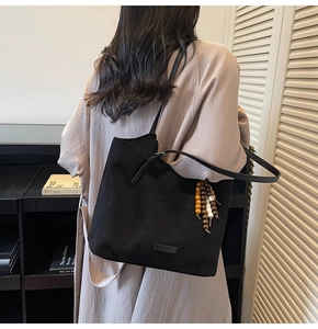 Détail du sac cabas noir avec pendentif en perles vintage et fine bandoulière