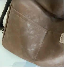 Detail of soft matte brown tote bag showing smooth texture and reinforced stitching