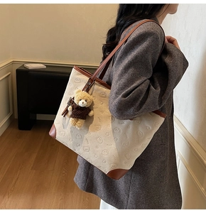 Detailed close-up of ivory canvas tote bag with bear pattern and brown leather trim