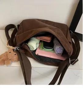 Detailed interior of a large brown canvas tote showing tablet and accessories storage