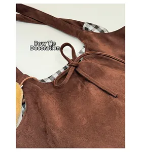 Détail du sac cabas en suède avec décoration en nœud et doublure à carreaux noir et blanc