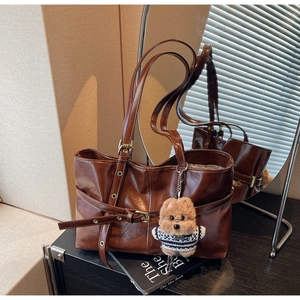 Détail du sac cabas marron en similicuir avec boucle ajustable et pendentif chien peluche