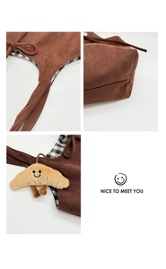 Détail du sac cabas en suédine marron avec doublure à carreaux et breloque croissant