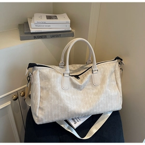 Detail of premium woven texture and beige shoulder strap on large weekend travel bag