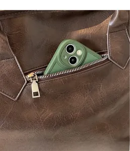 Détail de la poche zippée latérale du sac en cuir rétro avec un téléphone pour l'échelle