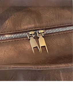 Détail macro de la fermeture éclair en métal lisse et du grain du sac de voyage marron