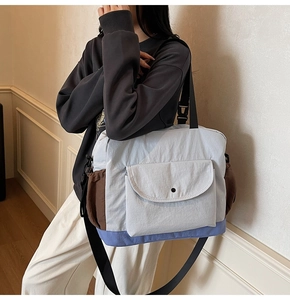 Detailed side view of large capacity crossbody bag with brown color-block side pocket