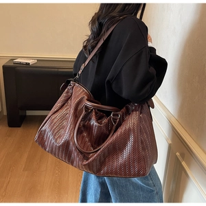Detailed view of dark brown woven texture on large capacity travel duffel bag