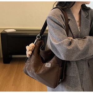 Detail of coffee canvas tote with wide shoulder strap and cute teddy bear charm pendant