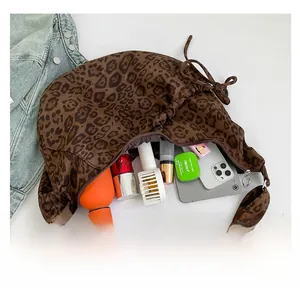 Spacious interior of leopard print dumpling bag showing storage for water bottle and cosmetics