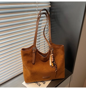 Détails de texture du sac cabas en daim marron avec franges perlées et longues bandoulières