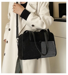 Detail of black crossbody bag featuring silver studs and suede leather texture