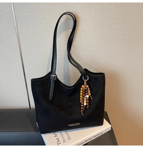 Détail du sac cabas en daim noir avec perles en bois et bandoulière en cuir