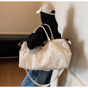 Detail of cream woven gym bag showing large capacity and textured woven pattern finish