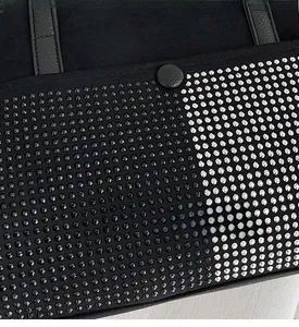 Macro view of stylish black tote bag with silver and black metallic studs detailing