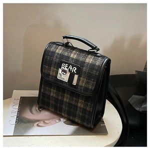 Détail de l'écusson ours et du tissu à carreaux sur ce sac à dos vintage de style collège