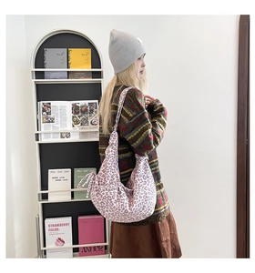 Detailed view of pink leopard print hobo bag with wide shoulder strap and side knot detail