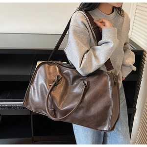 Gros plan du grand sac de voyage en cuir rétro marron avec détails de bandoulière réglable