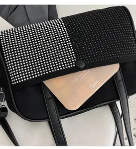 Detail showing the practical side pocket and rhinestone-studded flap of a black shoulder bag