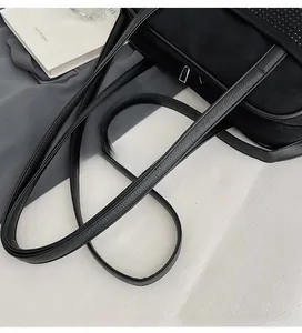 Detail of the black leather long shoulder strap with pebbled texture and metal zipper