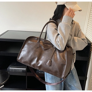 Vue latérale du grand sac cabas rétro marron foncé avec deux poignées et bandoulière
