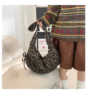 Detailed view of leopard print dumpling bag with pleated texture and side bow drawstring
