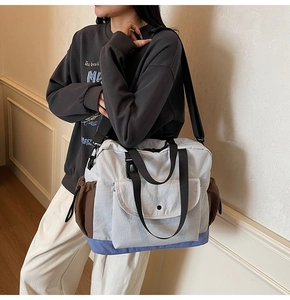 Detail of color-block nylon tote bag with drawstring pockets and adjustable shoulder strap