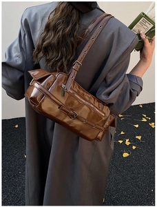 Detailed view of vintage brown patent leather bowling bag with silver hardware and buckles