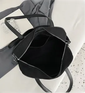 Interior detail of large black shoulder bag showing organized compartments and zipper pockets