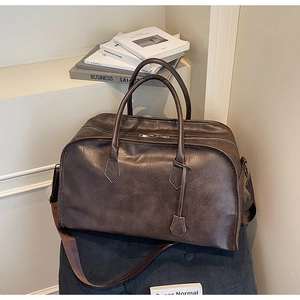 Vue détaillée du grand sac de voyage vintage en similicuir marron avec doubles poignées