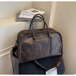 Vue détaillée du sac de voyage marron vintage à grande capacité et doubles poignées
