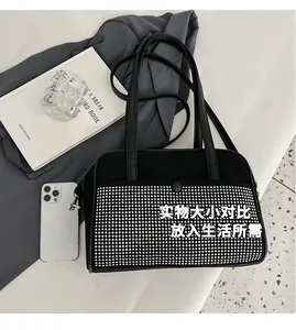 Detail view of the black leather shoulder bag showing its large capacity for daily items