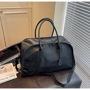 Détails macro d'un grand sac de voyage noir en similicuir grainé avec bandoulière amovible