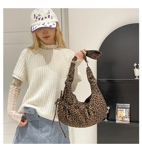 Detailed view of leopard print crossbody bag with drawstring design and wide strap