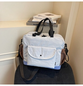 Close-up of color-block nylon tote bag with functional pockets and adjustable strap
