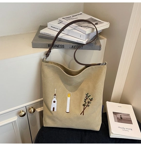 Detail of vintage beige canvas tote bag with embroidered church and olive branch pattern