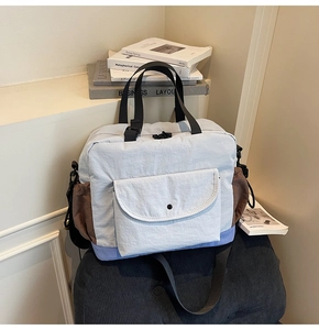 Close-up of color-block commuter bag showing side pocket and adjustable black strap